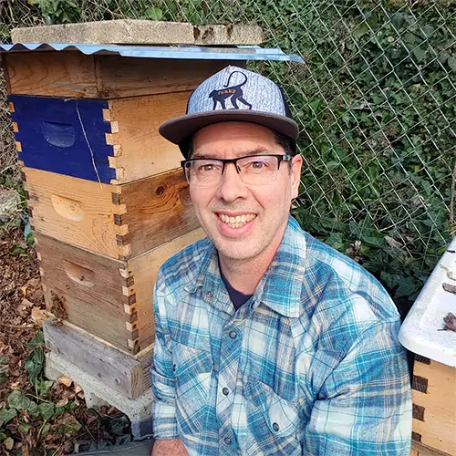 Brent Hefley beside honey bee hives